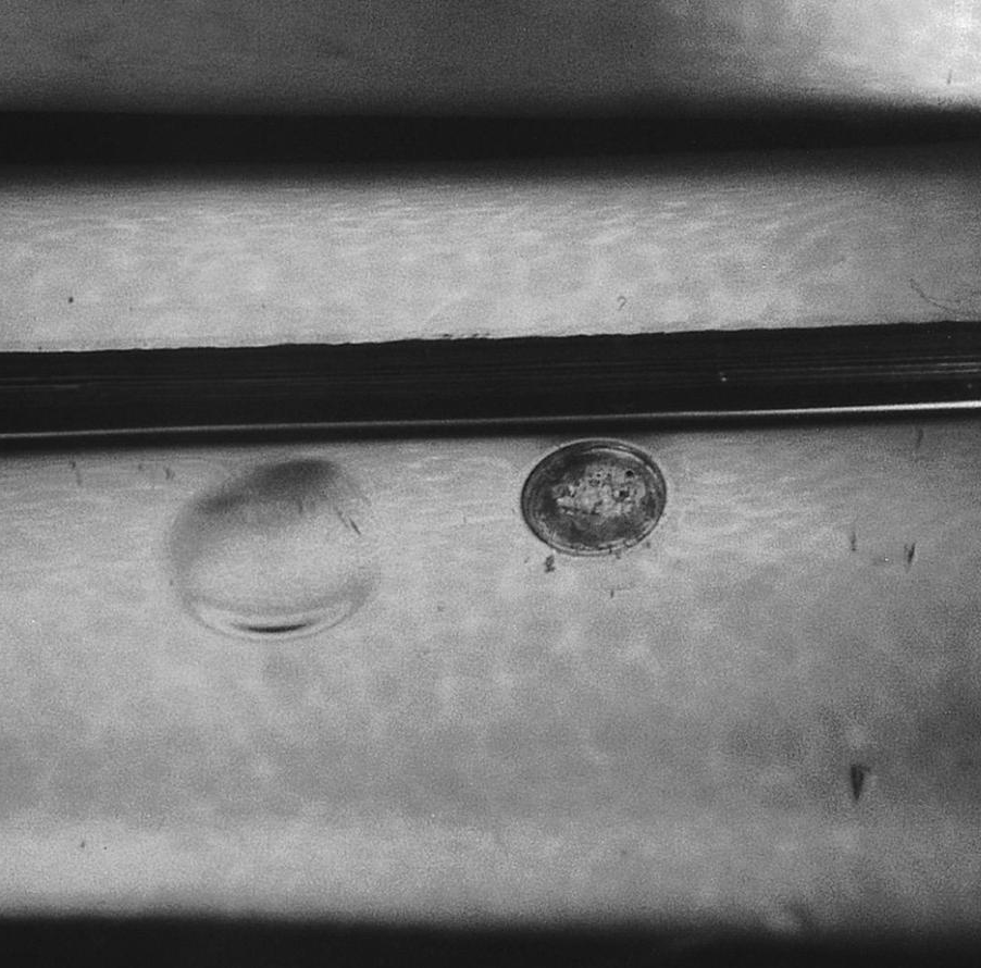 A blister and a hole (in the paint) at the gate from outgassing (4X).