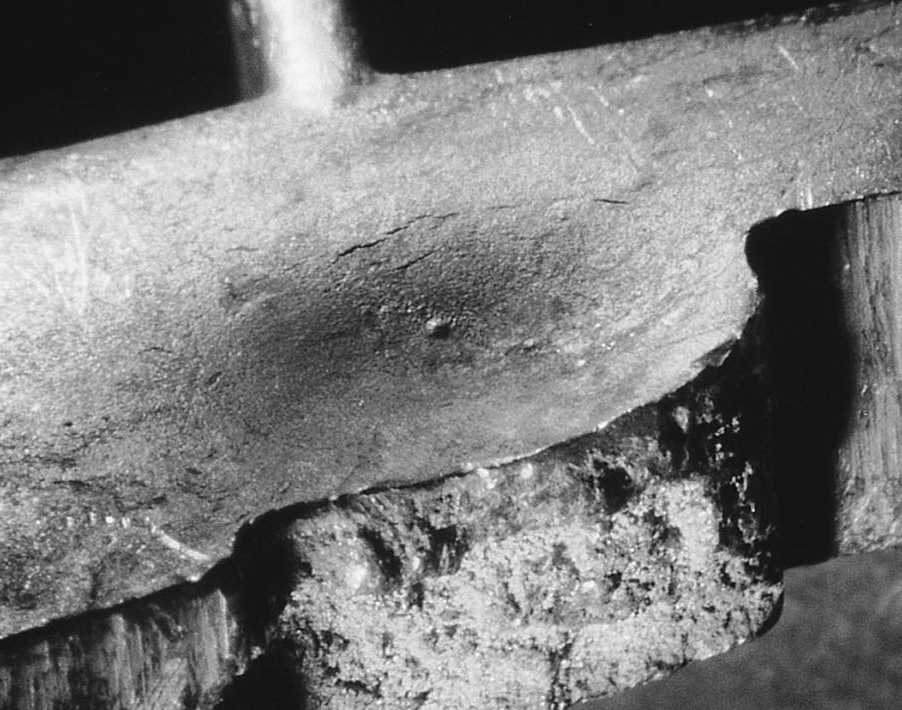 Fracture through a heat sink – the original shrink porosity under the skin is visible (7X).