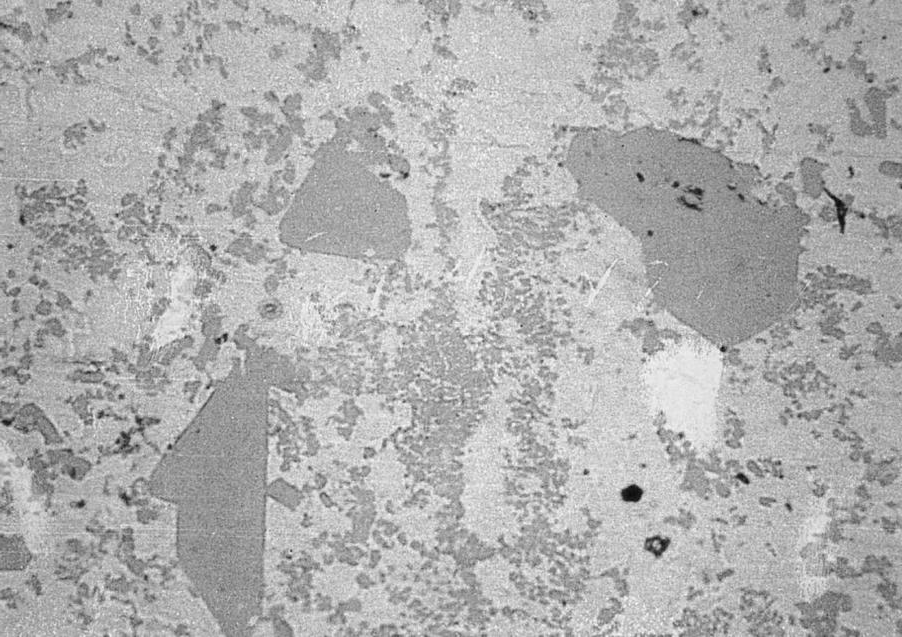 Surface dross laden with large and small FeAl3 inter-metallic particles (200X).