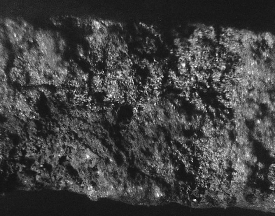 Typical internal shrink-age in a fracture through a leakage area. Note the continuous irregular paths (black) character-istic of shrinkage voids, which are interconnect-ed through the casting wall. Normally, close inspection will show evidence of internal